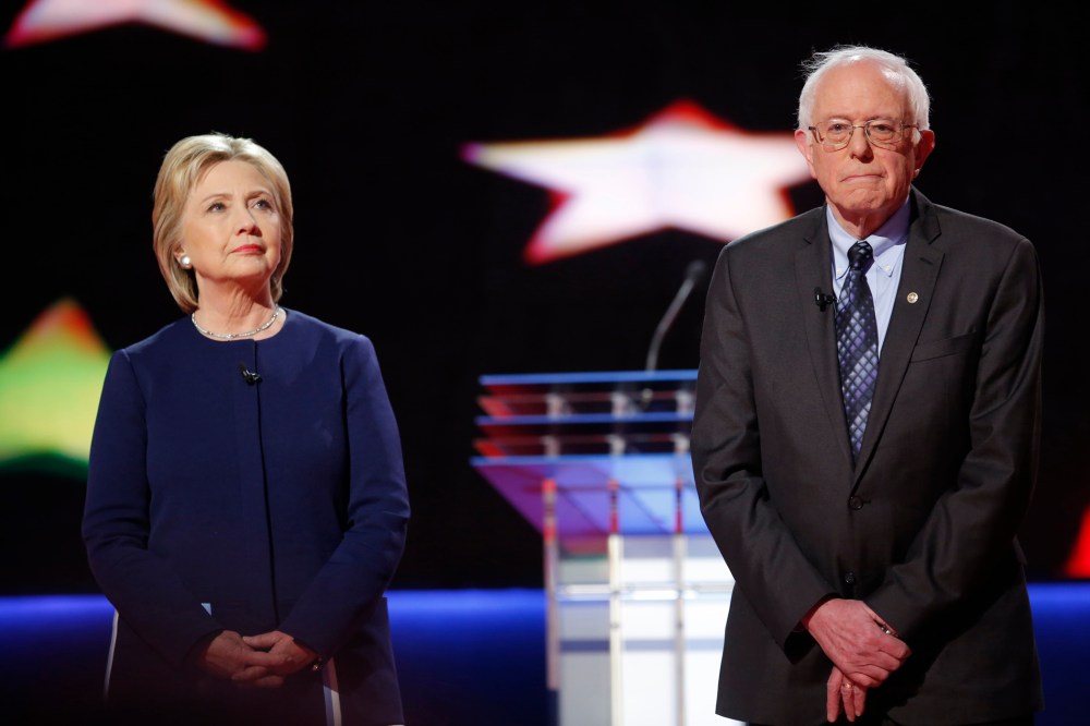 Democratic U.S. presidential candidates Hillary Clinton and Bernie Sanders pose together onstage at the start of the U.S. Democratic presidential candidates' debate in Flint, Mich. on March 6, 2016. (Photo by Carlos Barria/Reuters)