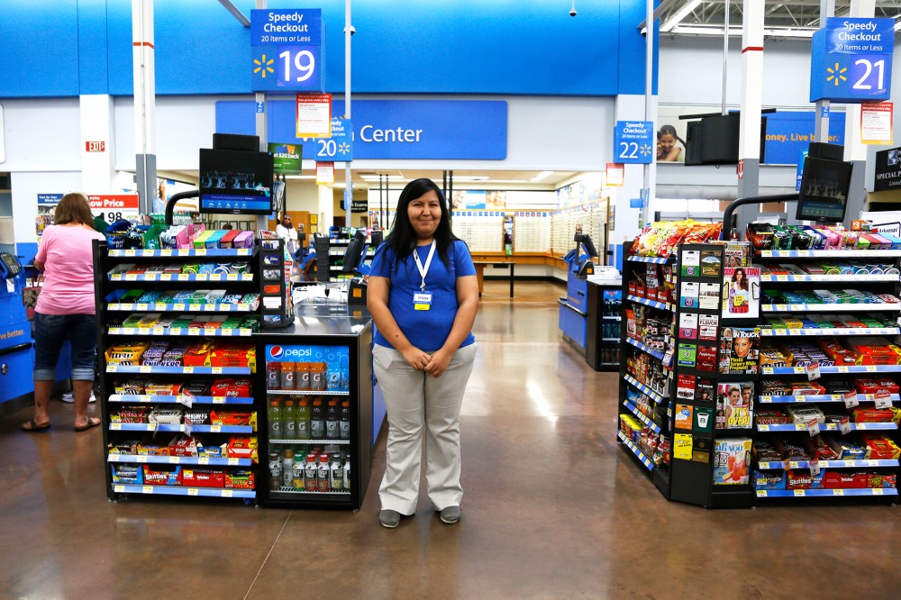 A cashier waits for customers at a Walmart Supercenter in Rogers, Arkansas June 6, 2013.