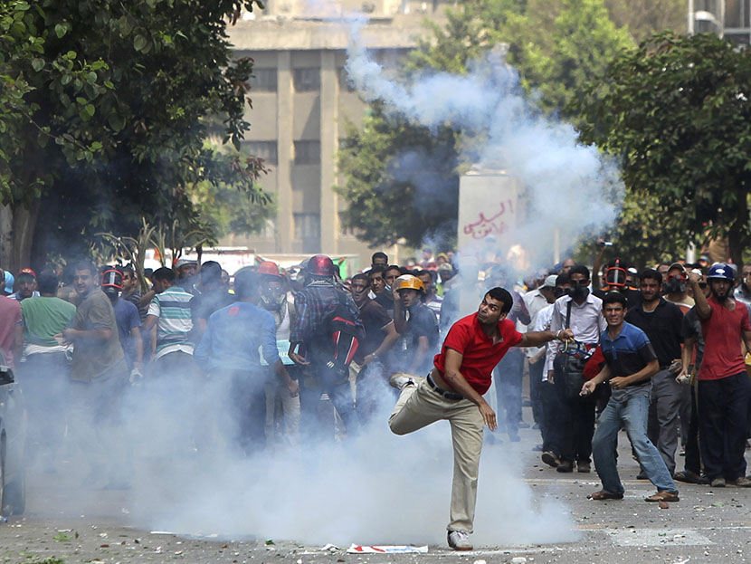 A supporter of ousted President Mohamed Mursi throws a tear gas canister back towards the police during clashes in central Cairo August 13, 2013. (Photo by Asmaa Waguih/Reuters)