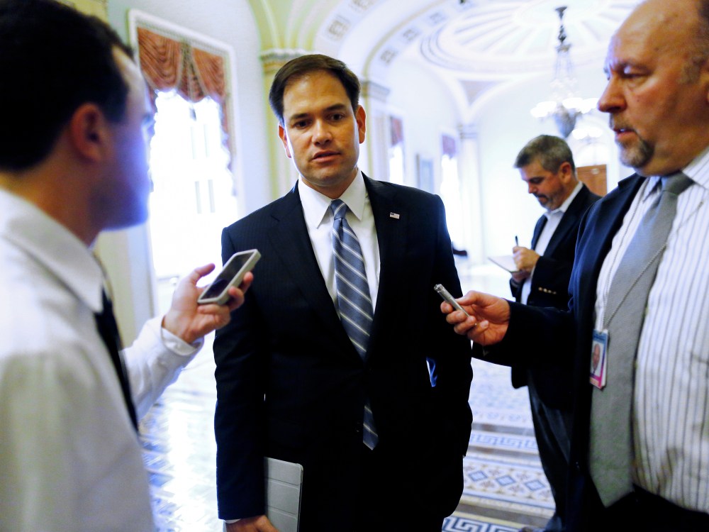 U.S. Senator Marco Rubio talks to reporters on his way to vote on the Senate floor at the U.S. Capitol in Washington, October 12, 2013.
