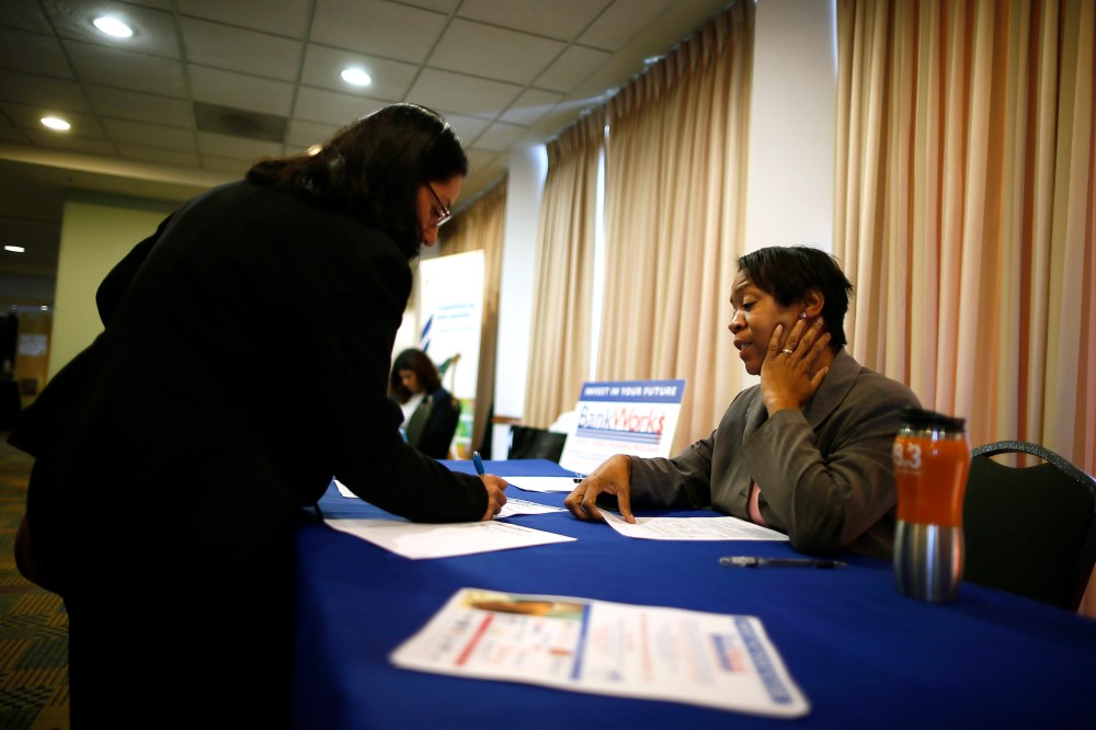 Alese Pedro, from JVS-BankWorks (R), talks to job seeker Gloria Cuellar, 38, at a job fair in Los Angeles, Calif. on Nov. 18, 2013.
