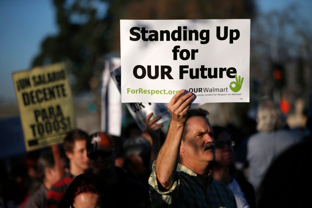 A demonstrator holds up a sign during a protest outside Wal-Mart for better wages and working conditions during Black Friday in San Leandro, Calif. on Nov. 29, 2013.