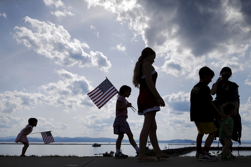 A Vermont family waits for U.S. Senator Bernie Sanders to kick off his presidential campaign on the shore of Lake Champlain in Burlington, which is lined by New York mountains on the horizon, May 26, 2015. (Photo by Brian Snyder/Reuters)