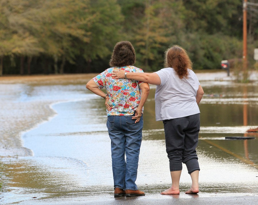 Neighbors console each other after floods waters entered their business in Elba, Ala., Dec. 26, 2015. (Photo by Marvin Gentry/Reuters)