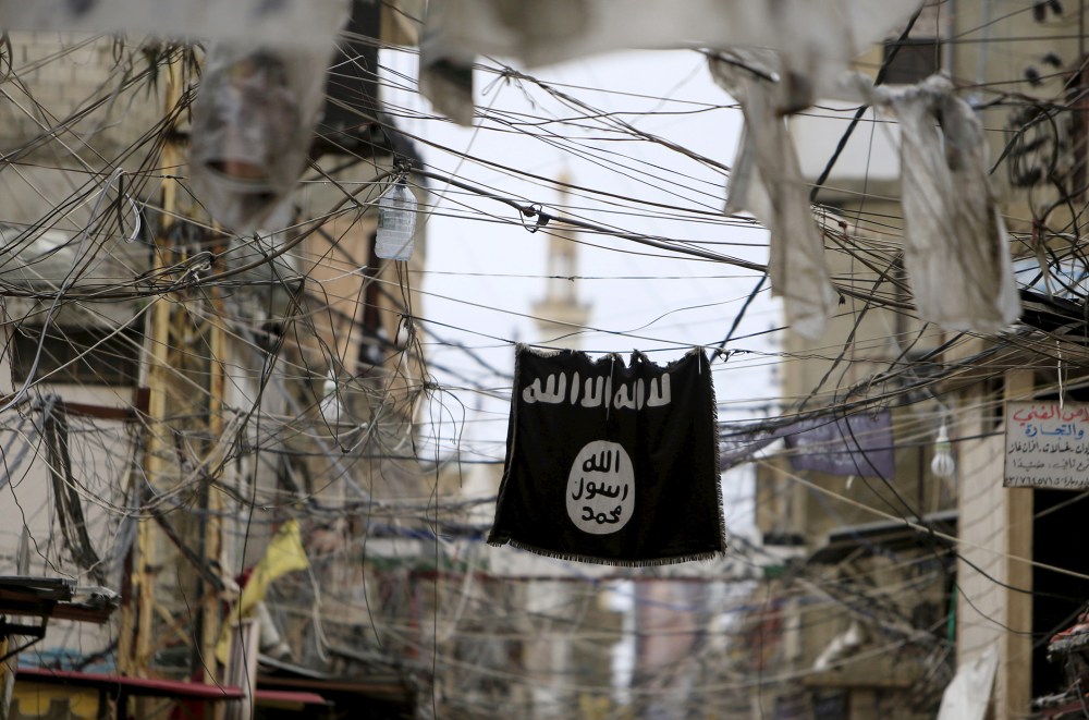 An Islamic State flag hangs amid electric wires over a street in Ain al-Hilweh Palestinian refugee camp, near the port-city of Sidon, southern Lebanon, Jan. 19, 2016. (Photo by Ali Hashisho/Reuters)