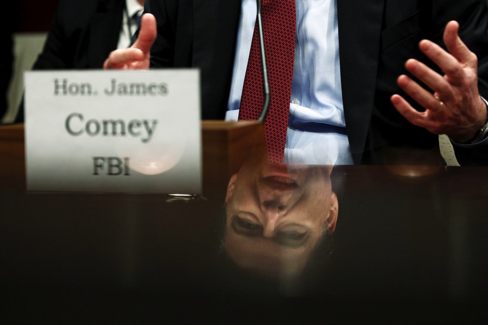 FBI Director James Comey is seen in a reflection as he testifies in a House Appropriations hearing on "World Wide Threats" on Capitol Hill in Washington, Feb. 25, 2016. (Photo by Kevin Lamarque/Reuters)