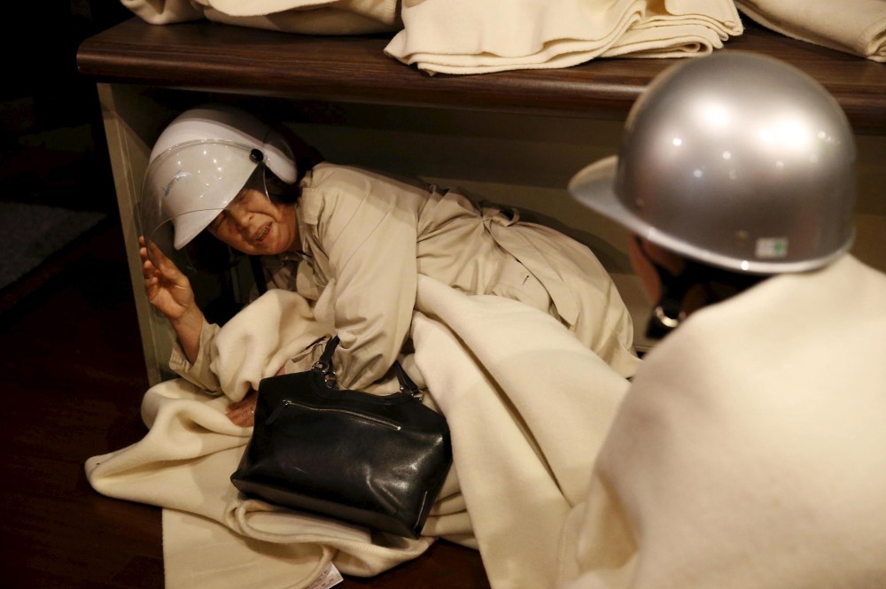 A woman takes shelter after another earthquake hit the area at a hotel in Kumamoto, southern Japan, in this photo taken by Kyodo April 16, 2016. (Photo by Kyodo/Reuters)