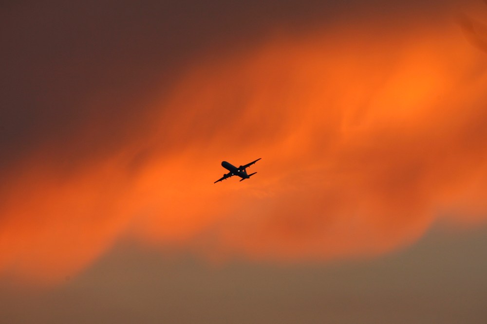 A passenger aircraft flies against the backdrop of monsoon clouds in New Delhi