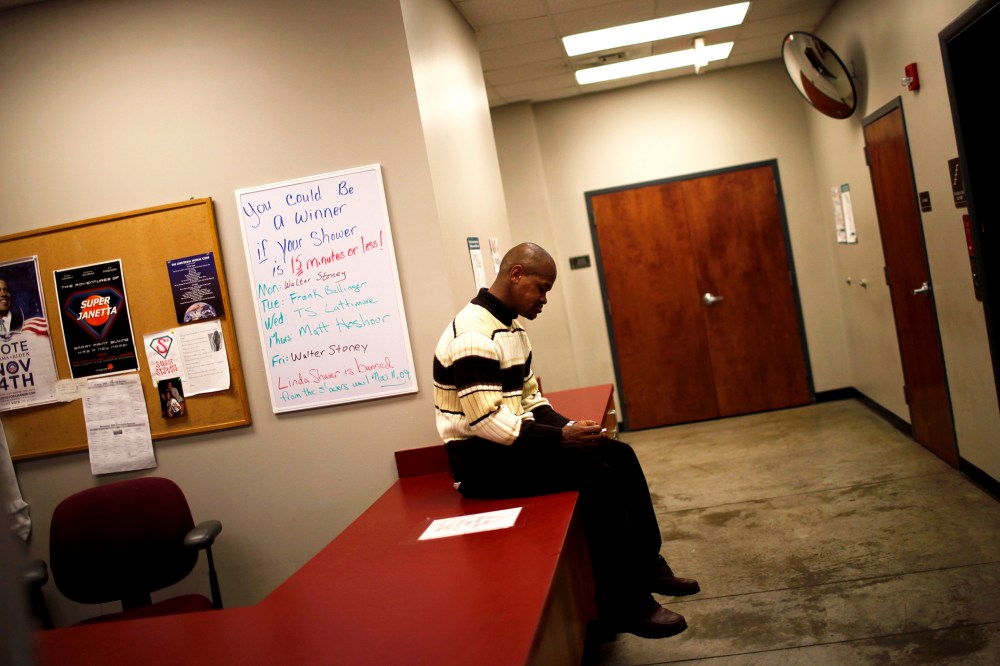A man sits on a table at the Urban Ministry soup kitchen in Charlotte, N.C.