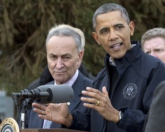 President Barack Obama gestures as he speaks during a news conference on Cedar Grove Avenue, a street significantly impacted by Superstorm Sandy, Thursday, Nov. 15,2012, on Staten Island, with New York Sen. Chuck Schumer. (AP Photo/Carolyn Kaster)