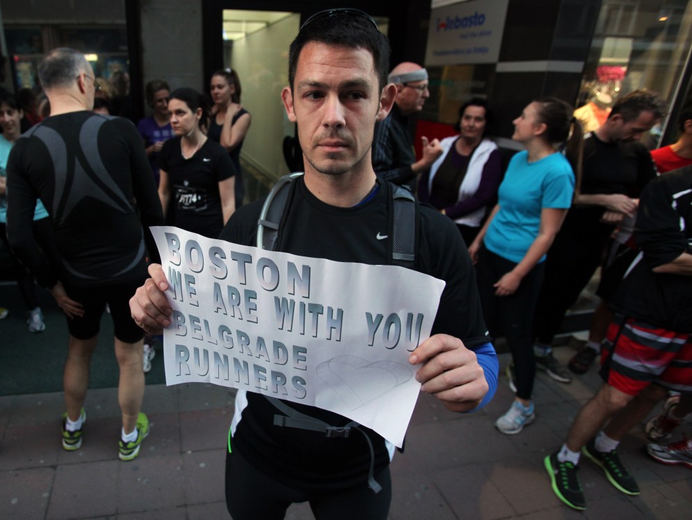 A runner shows a banner reading: "Boston we are with you - Belgrade runners" in an organized memorial run to show solidarity with victims of the Boston Marathon bombing, Tuesday, April 16, 2013, in Belgrade, Serbia. (Photo by Darko Vojinovic/AP Photo)