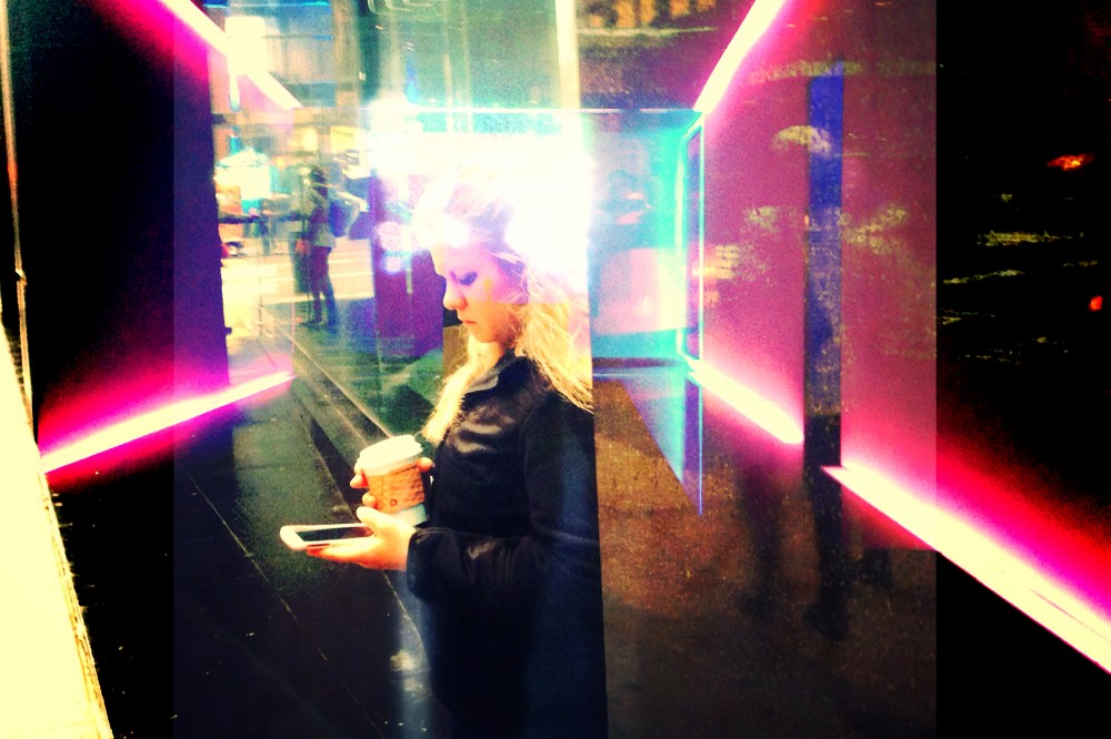 A woman checks her phone on the street in New York City.