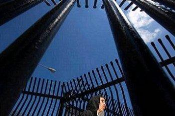 A young man stands in the gates at the U.S.-Mexico border awaiting his deportation at the port of entry in Tijuana.