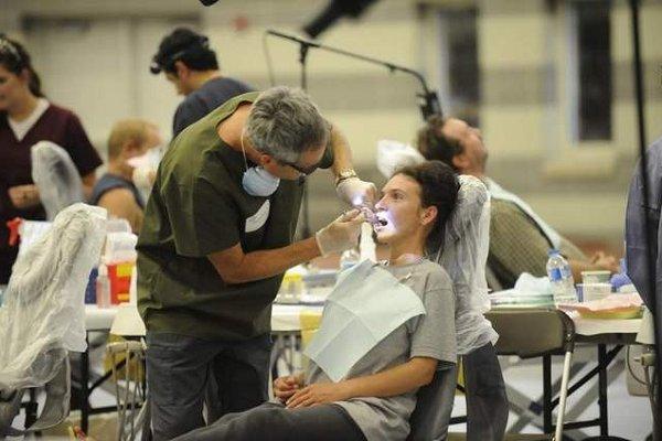 A dentist extracts a tooth from an uninsured patient at a mobile clinic in Sewanee, Tenn.