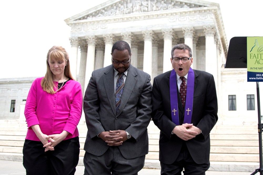 Rev. Dr. Rob Schenck, of Faith and Action, right, prays in front of the Supreme Court with Raymond Moore, center and Patty Bills, both also of Faith and Action, during a news conference, on May 5, 2014, in Washington.