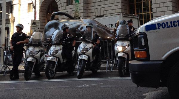 Police officers block the Charging Bull sculpture at Bowling Green Park near Wall Street in New York City on September 17, 2012.