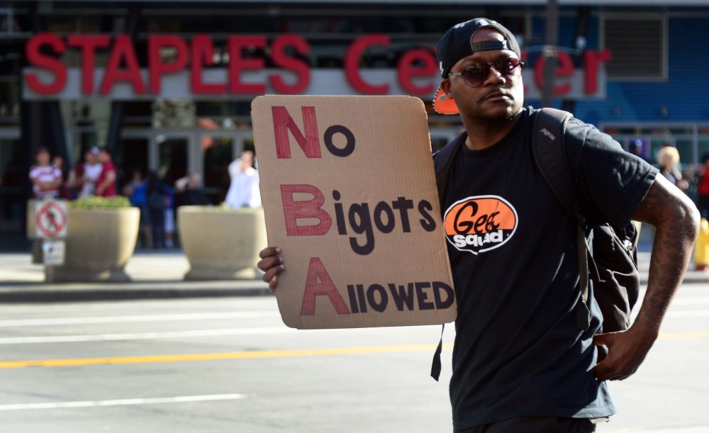 A man carries a message as people gathered to protest outside Staples Center, April 29, 2014 in Los Angeles, California.