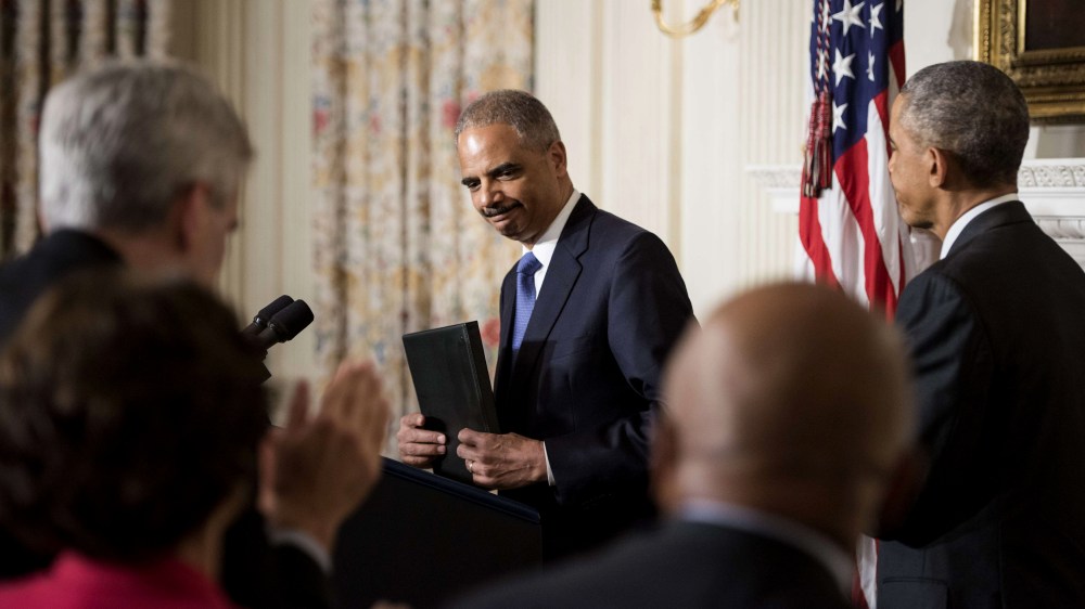 US President Barack Obama (R) listens while US Attorney General Eric H. Holder, Jr., speaks during an event in the State Dining Room of the White House Sept. 25, 2014 in Washington, DC.