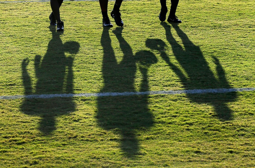 Baltimore Ravens wide receivers cast shadows as they walk off the field after NFL football training camp, Aug. 8, 2015, in Owings Mills, Md.