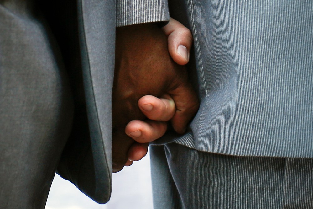 Hank Hamilton and his partner Larry Clement (L) hold hands during their same-sex marriage ceremony in a mass ceremony at Unity in Chicago in Chicago, Illinois, June 1, 2014. Same-sex marriage became legal in the State of Illinois on June 1.