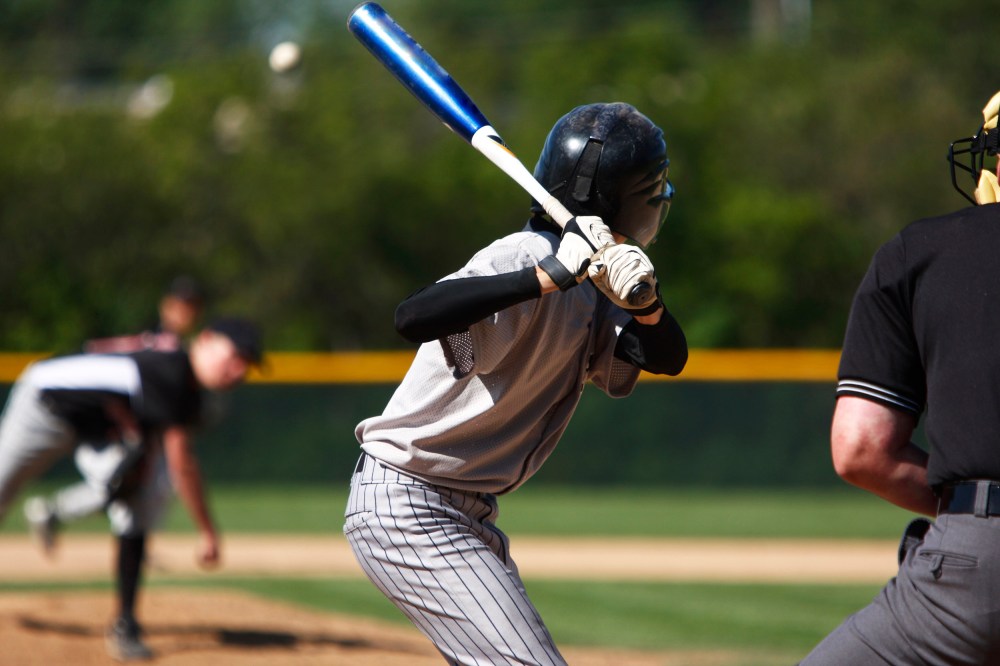 View of baseball batter from behind the catcher as they hit