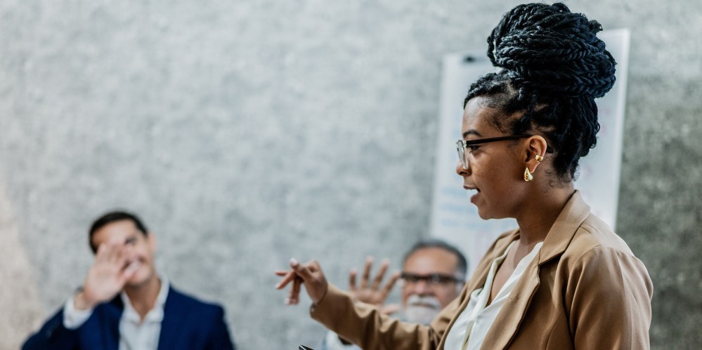 Businesswoman talking with coworkers in business meeting at office