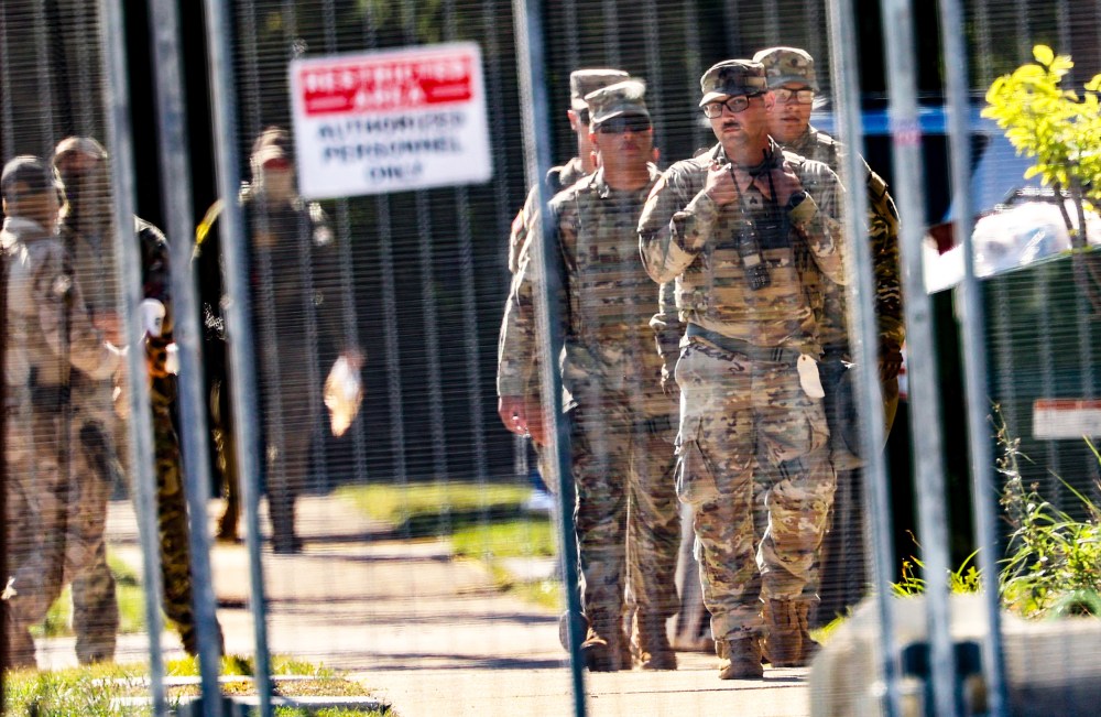 National Guard members walk around outside of the U.S. Immigration and Customs Enforcement holding facility.