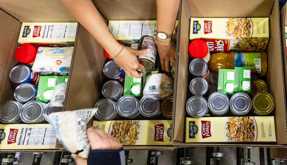 Workers pack boxes at The Orange County Food Bank.