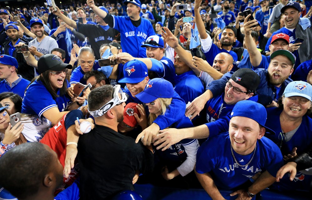 Marco Estrada #25 of the Toronto Blue Jays is swarmed by fans in Toronto, Canada.