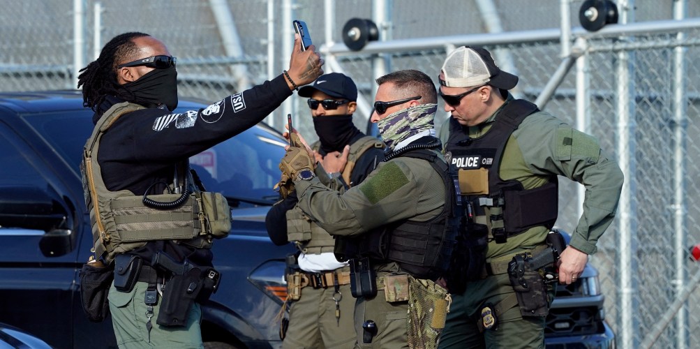 ICE agents use their phones near protestors at a demonstration in Newark, N.J. on May 7, 2025.
