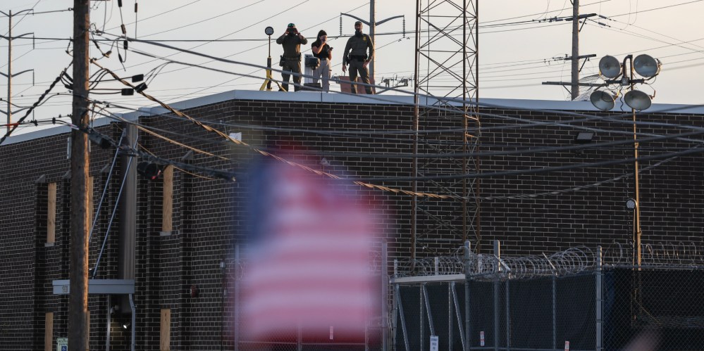 People on the roof of the immigration processing and detention center watch demonstrators in Broadview, I.L.