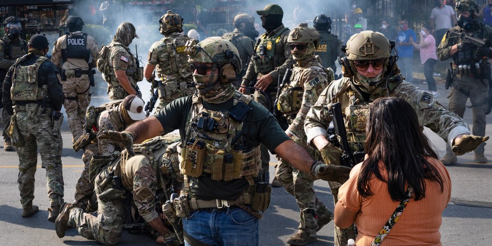Police take two people into custody, as tear gas fills the air after it was used by federal law enforcement agents in Broadview, IL.