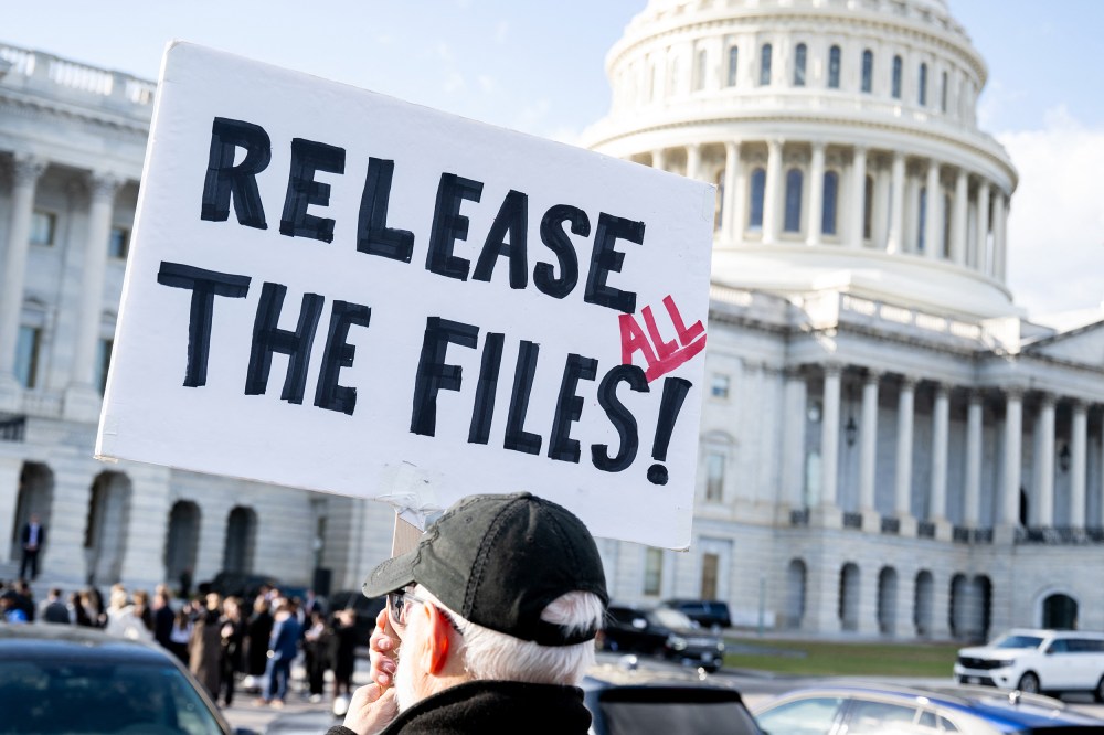 A protester holds a sign related to the release of the Jeffrey Epstein case files outside the Capitol.