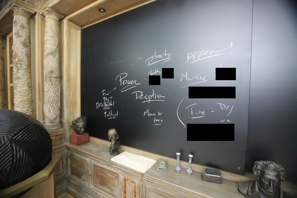 Writing on a blackboard, with details redacted by the Committee on Oversight and Government Reform.