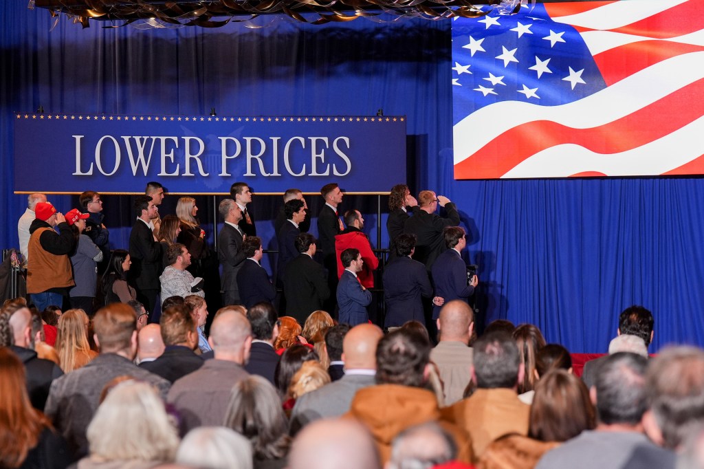 Attendees below a "Lower Prices" sign prior to an event on inflation in Mount Pocono, P.A., on Dec. 9, 2025.