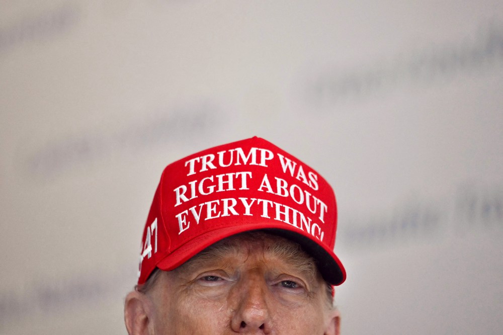 President Donald Trump wears a hat that reads "Trump was right about everything."