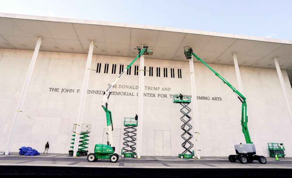 Workers affix signage adding US President Donald Trump's name on the facade of the Kennedy Center on Friday Dec. 19 in Washington, D.C.