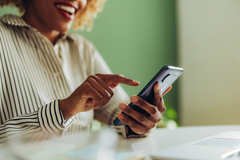 African American woman using social media on her phone.