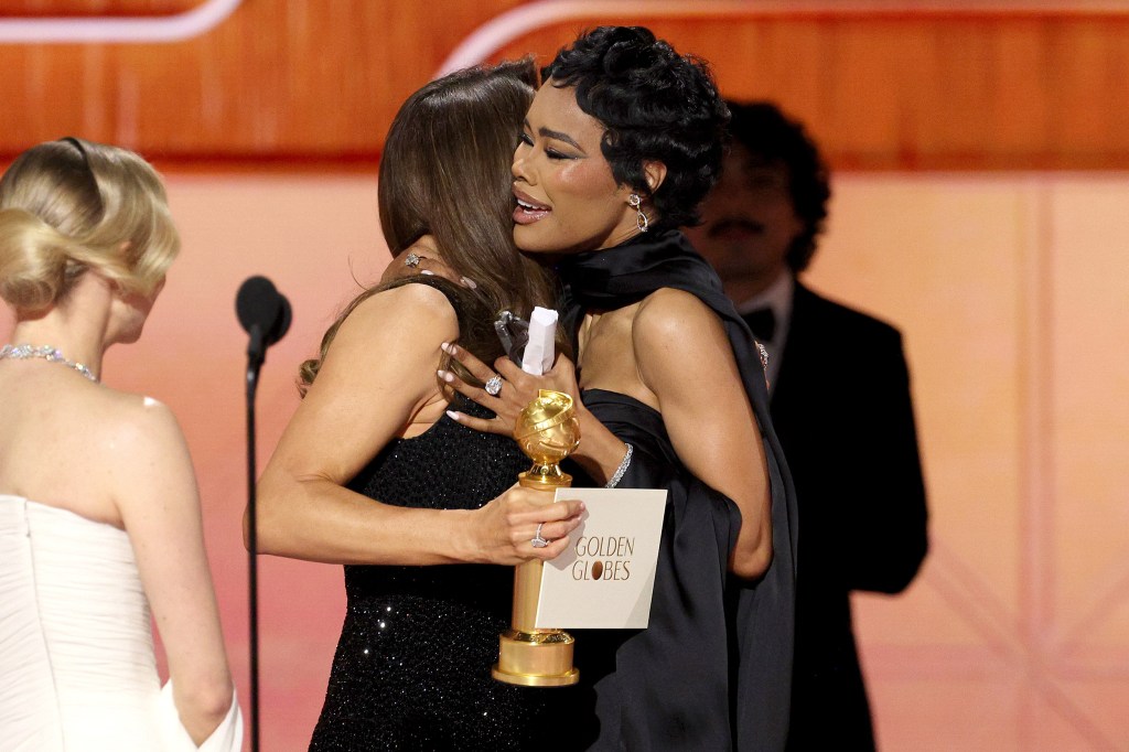 Teyana Taylor embraces Jennifer Garner, left, who holds a Golden Globe award.