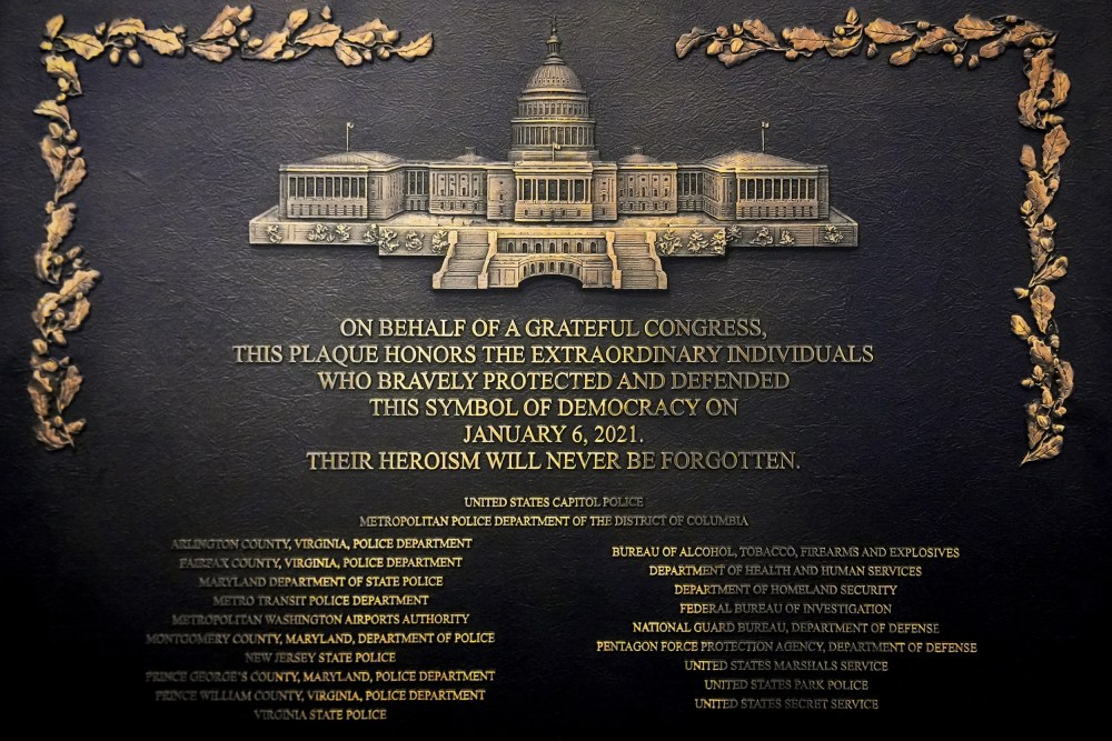A plaque reads, "On behalf of a grateful Congress, this plaque honors the extraordinary individuals who bravely protected and defended this symbol of democracy on January 6, 2021. Their heroism will never be forgotten."