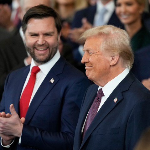 Vice President JD Vance claps as President Donald Trump smiles.
