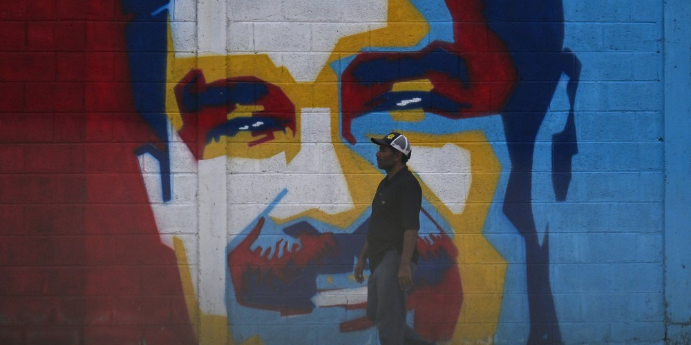A man walks past a graffiti depicting Venezuelan President Nicolas Maduro in Caracas on January 3, 2026.