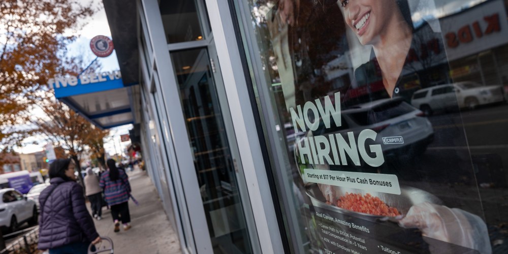 A “Now Hiring” sign is seen on a Chipotle window.
