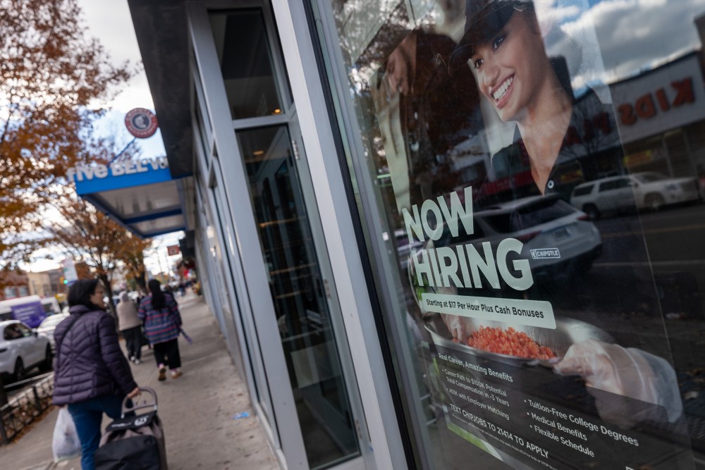 A “Now Hiring” sign is seen on a Chipotle window.