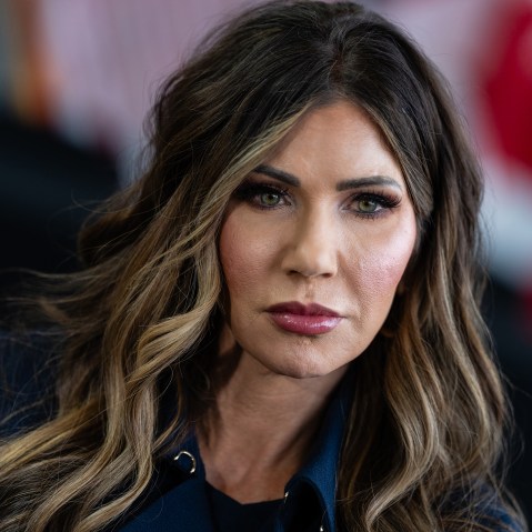 A tight tilted photo of Kristi Noem shows her displeased.