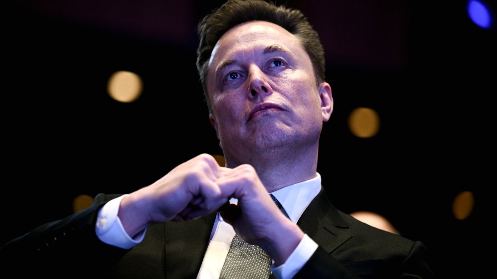 Elon Musk looking up at the stage while President Trump speaks.