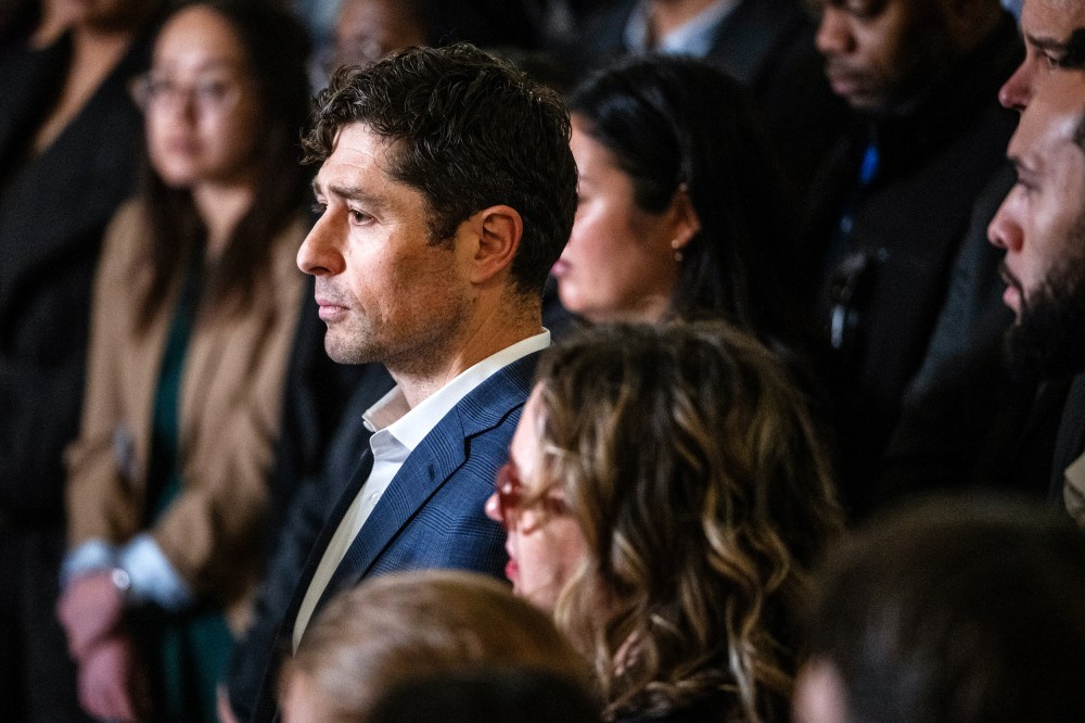 Minneapolis Mayor Frey stands in the middle of a big crowd. He is seen from the left side.