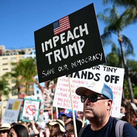 A protester holds a sign reading "Impeach Trump" during a "Hands Off!" rally in on April 05, 2025 in Los Angeles.