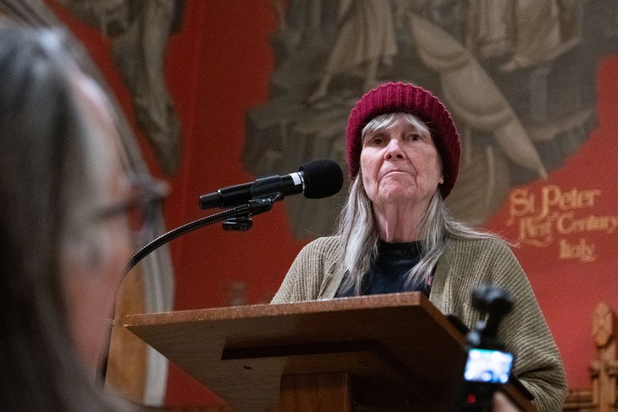 Joan Bell speaking at the podium.