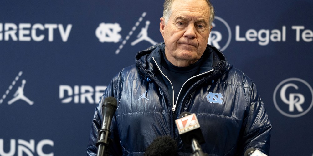 Bill Belichick looks down during a press conference.